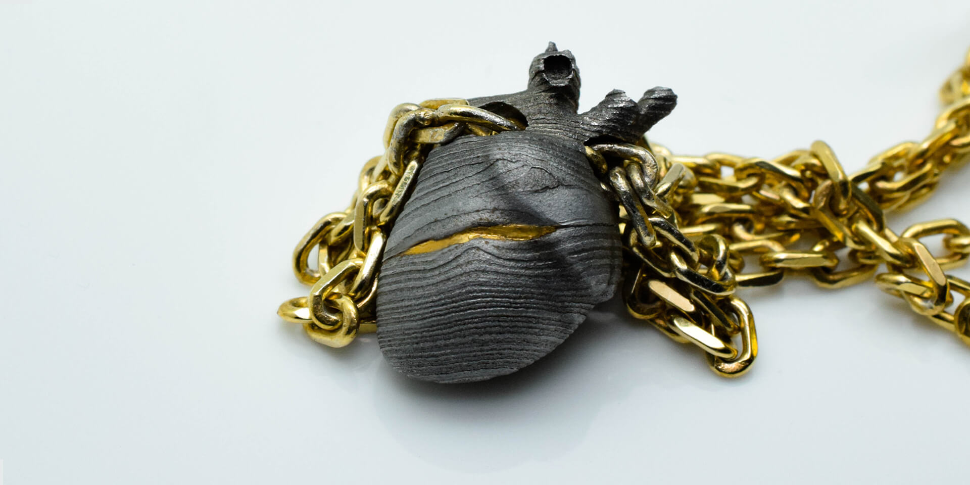 Anatomical heart pendant in oxidised silver with gold