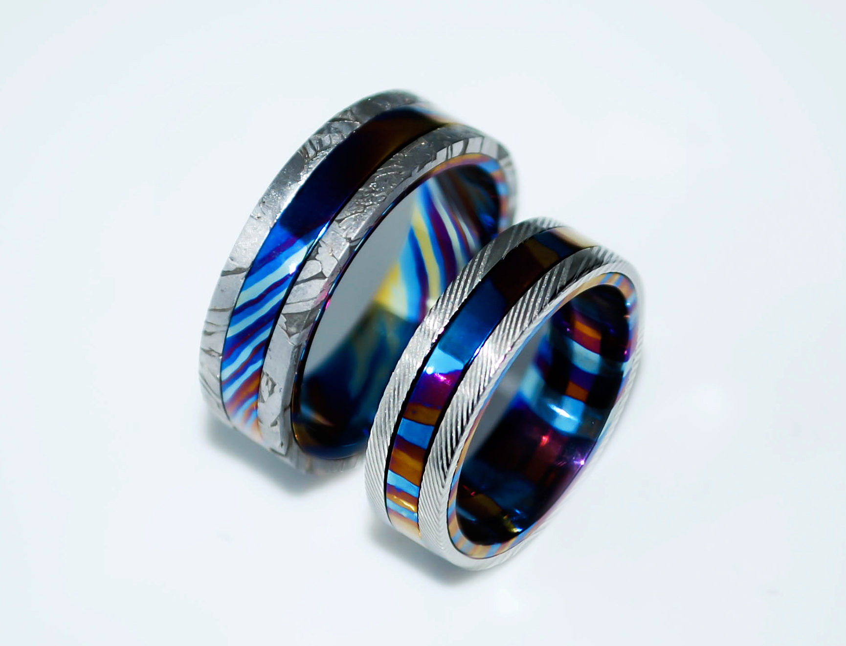 Set of wedding rings in Damascus steel with blue-toned titanium