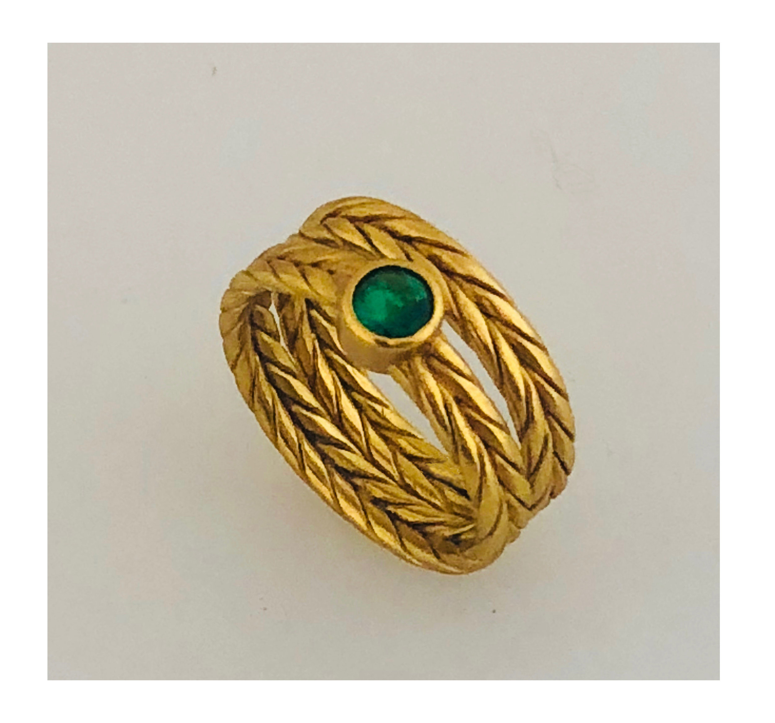Wide braided wire gold ring with emerald