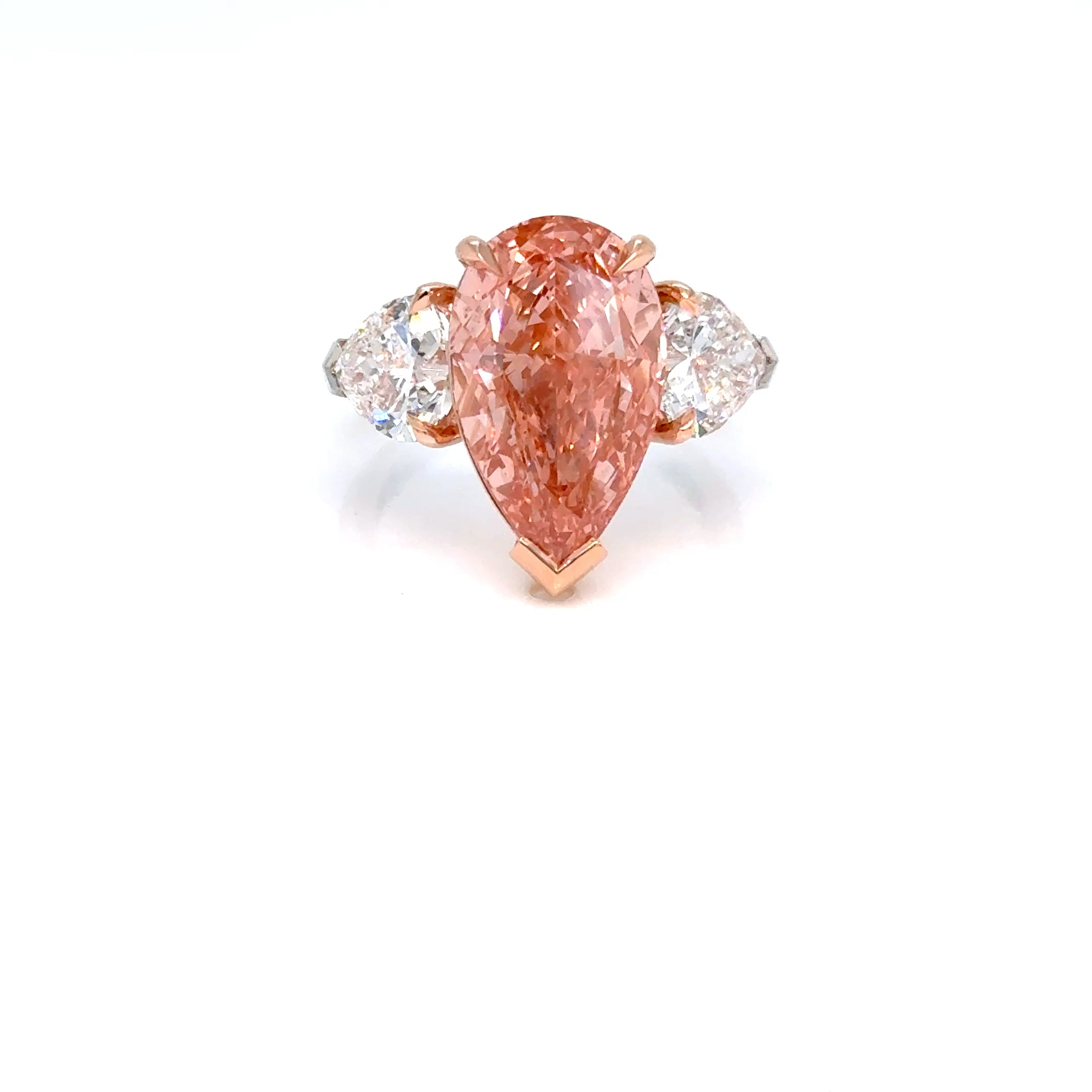 A pear-cut 7.10 ct pink diamond ring set in 18k white and rose gold, flanked by two round brilliant-cut diamon