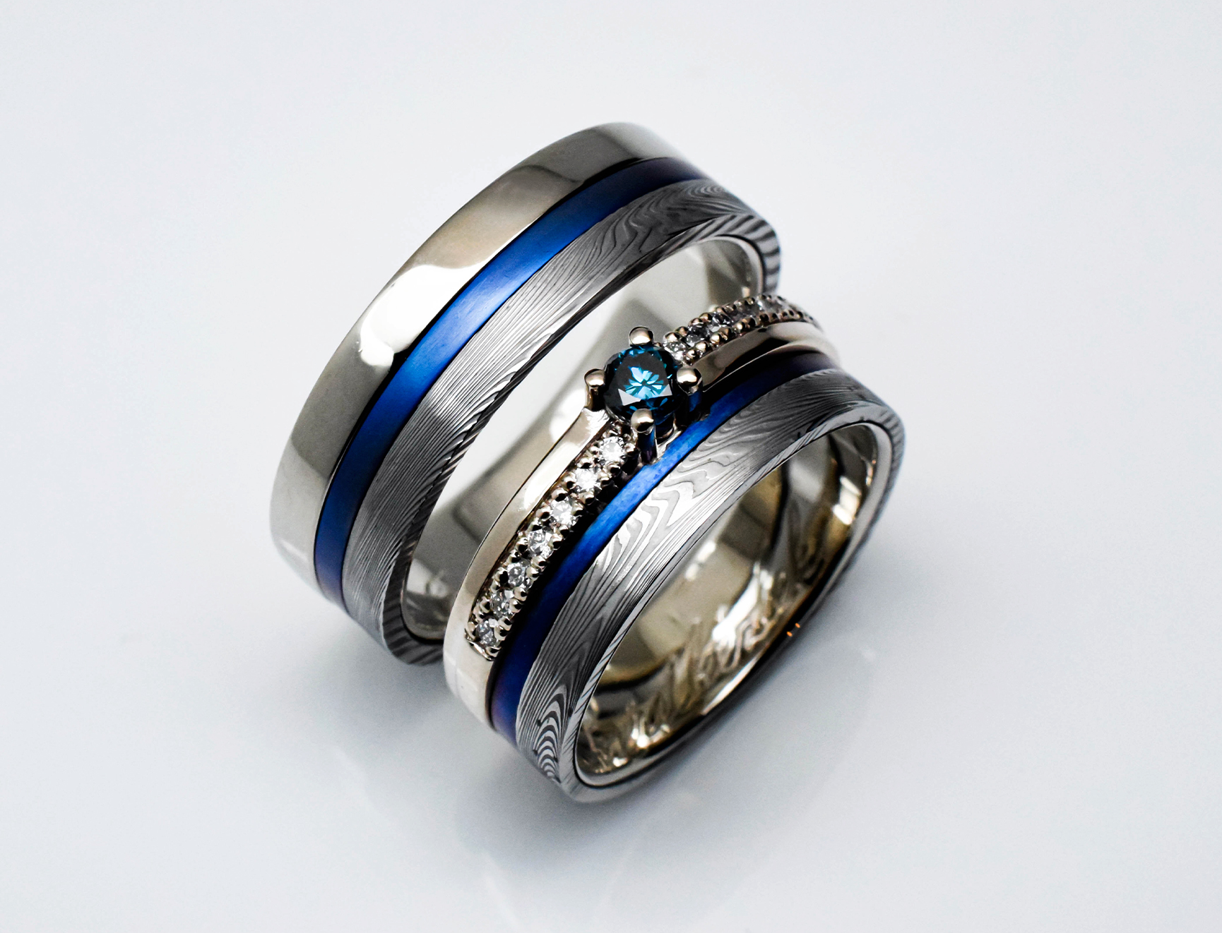 Wedding ring set with Damascus steel, blue titanium and diamonds