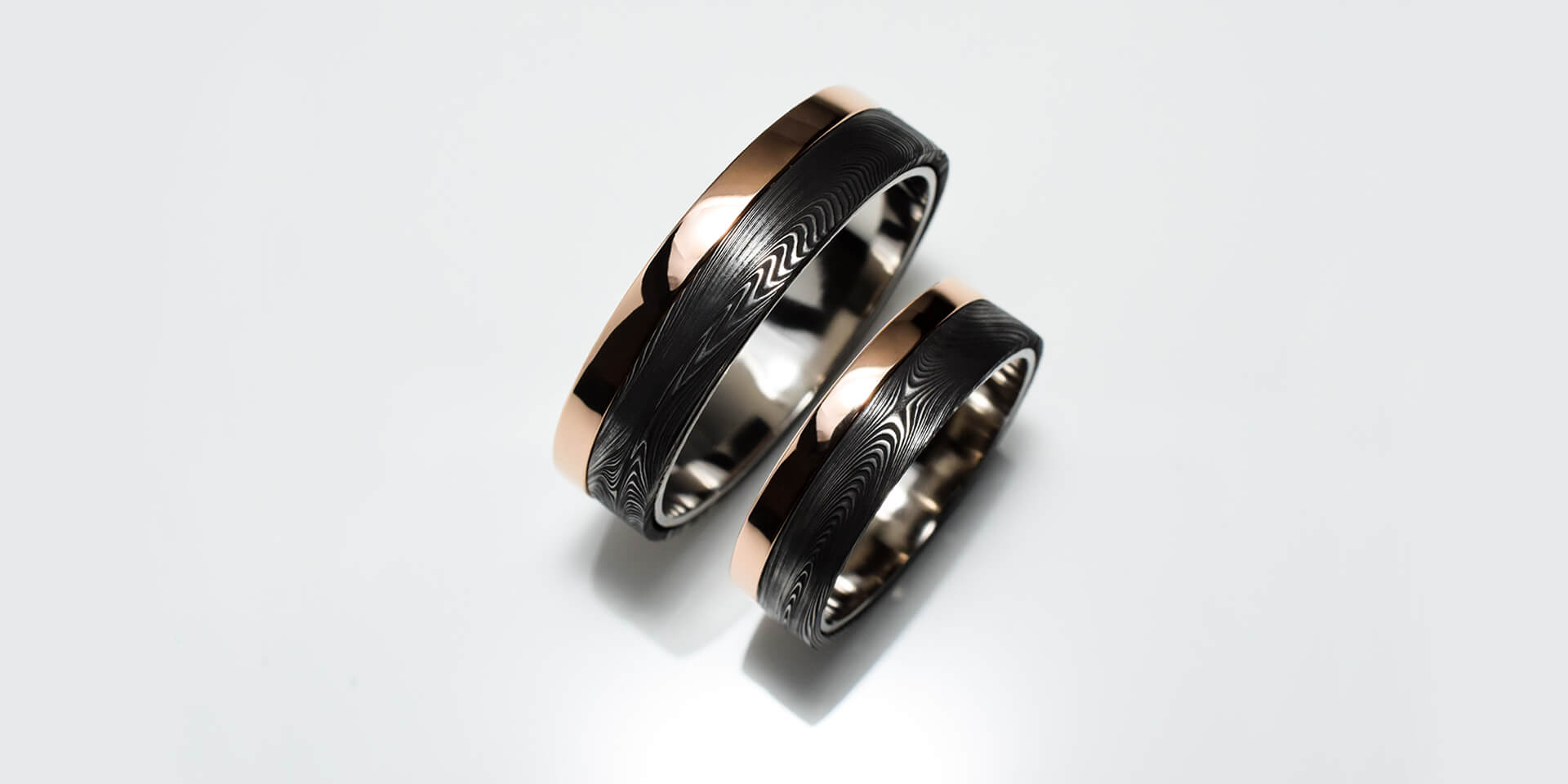 Wedding ring set in Damascus steel with rose gold