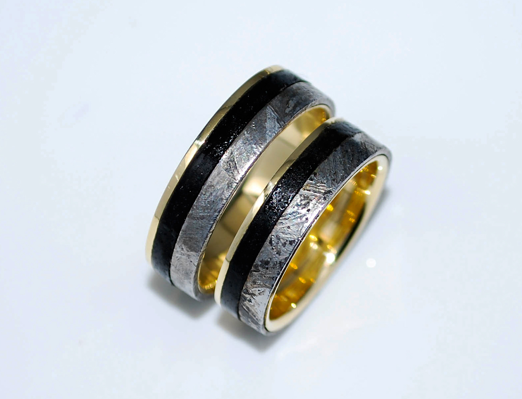 Set of yellow gold wedding rings with meteorite and black inlay