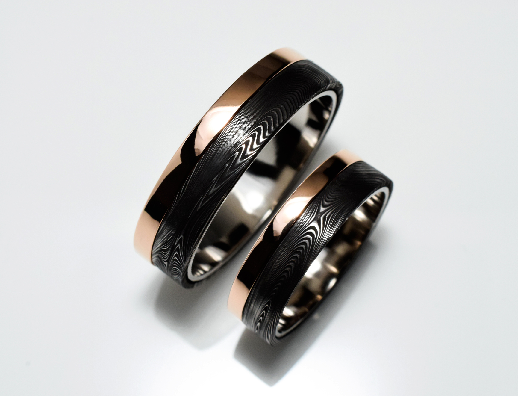 Wedding ring set in damascus steel with rose gold