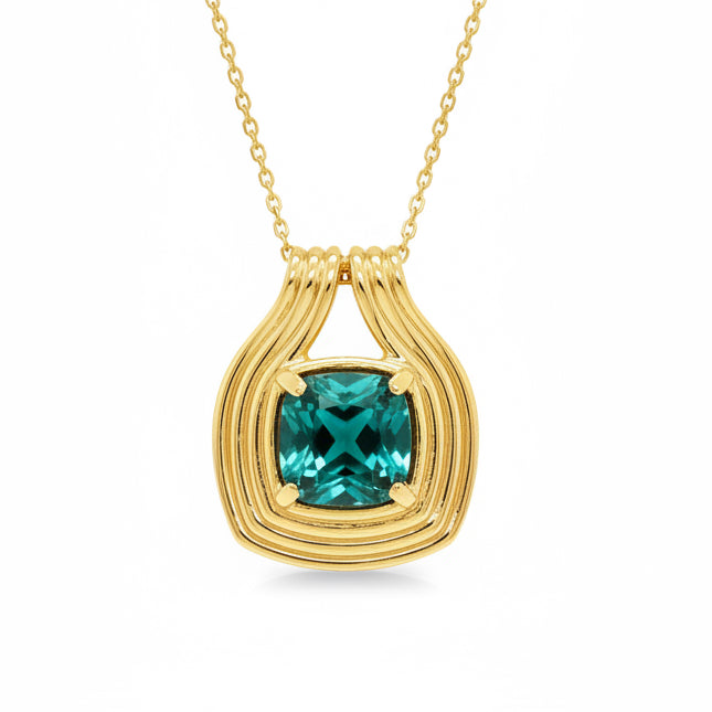 A 18k yellow gold pendant necklace featuring a faceted Blue lagoon Tourmaline gemstone in a textured, layered