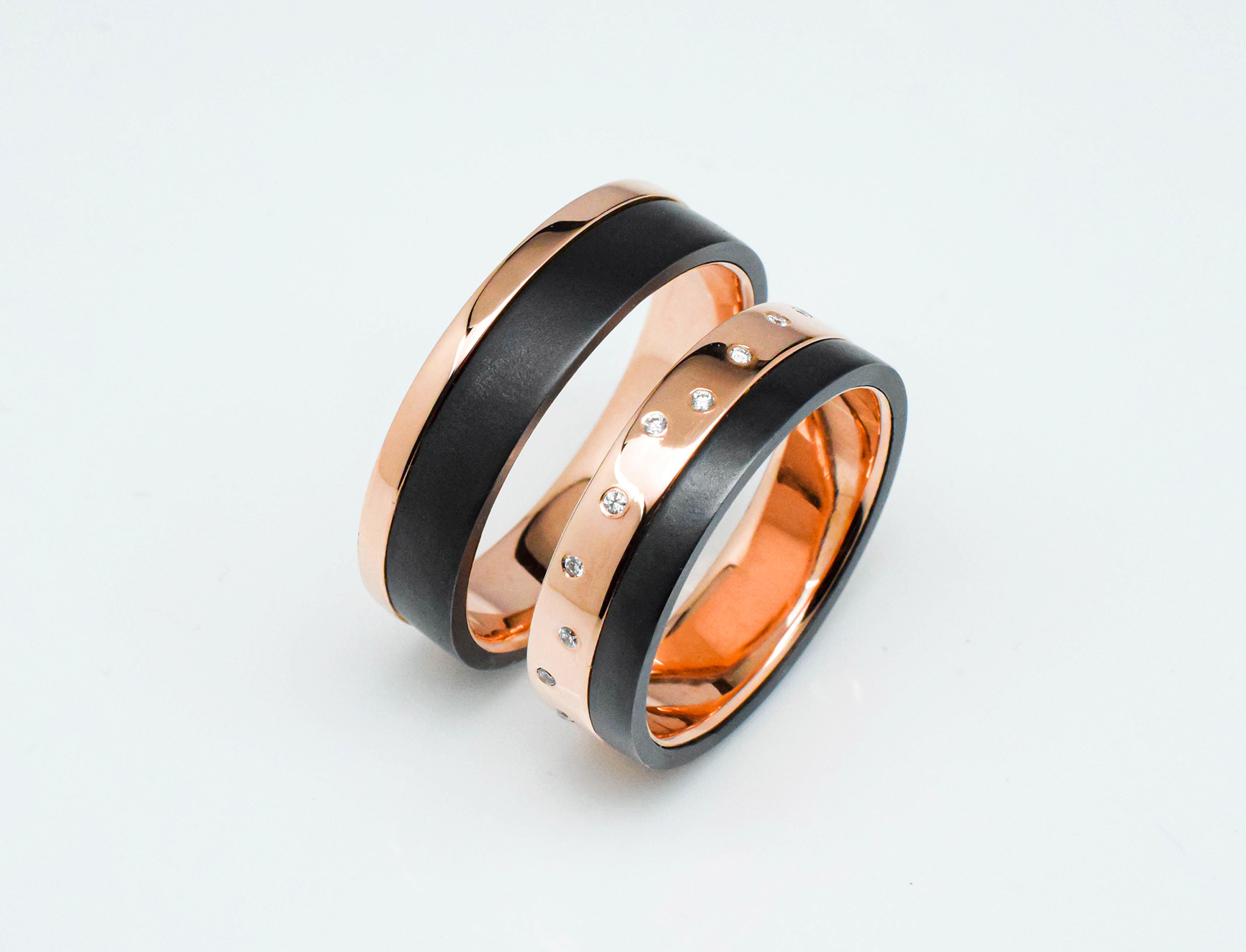Pair of wedding rings in rose gold with black and diamonds